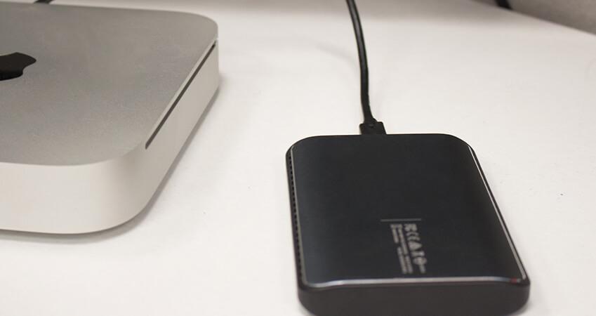 Showing an external backup drive next to a MacMin.